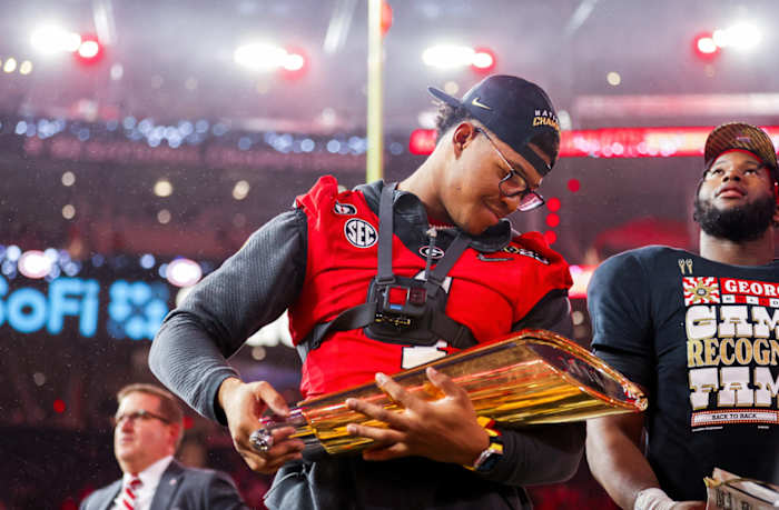 Nolan Smith with the 2023 national championship trophy after the Georgia Bulldogs defeated TCU by a score of 65-7